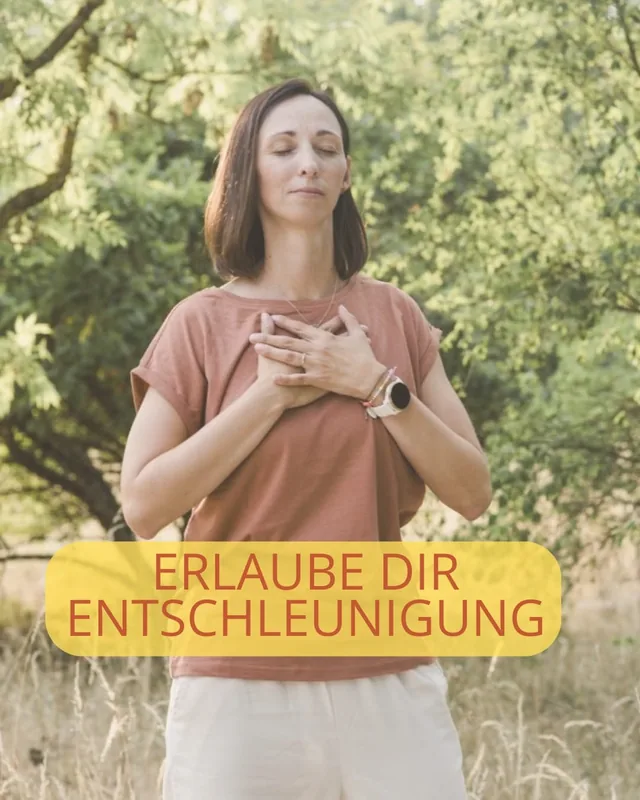Simone steht mit geschlossenen Augen und den Händen auf dem Herzen in der Natur, Instagram-Beitrag: Erlaube dir Entschleunigung.