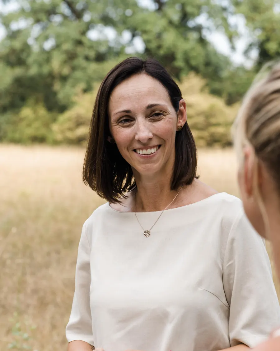 Simone Wiesinger-Springer im Gespräch mit einer Mama auf einer sommerlichen Wiese